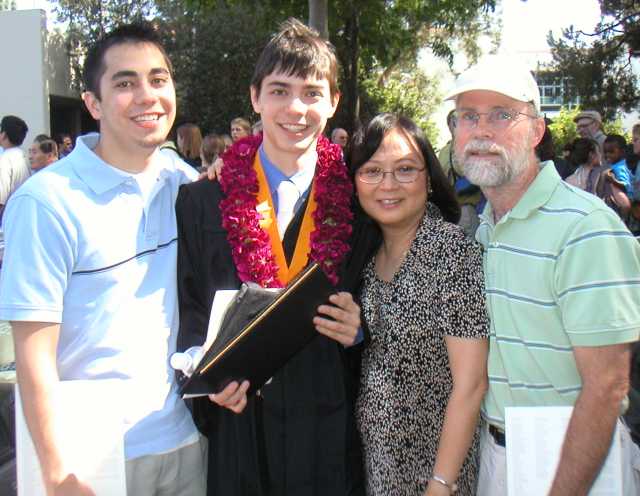 Devon in graduation gown with family